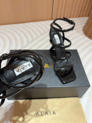 ALAIA THREE-STRAPS HIGH HEEL SANDALS IN BLACK PATENT LAMBSKIN