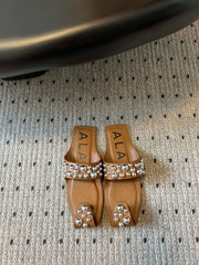 ALAIA FOLDED FLAT MULES WITH SPHERES ON COPPER BROWN CALFSKIN