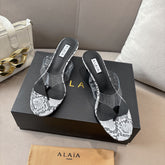 ALAIA HEELED THONG 25S 55 MM IN WHITE AND BLACK LAMBSKIN SNAKE-EMBOSSED WITH CLEAR STRAP
