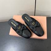 BOW MULES IN BLACK SHEEPSKIN