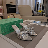 BOW-EMBELLISHED HIGH MULES IN SILVER METALLIC SHEEPSKIN