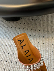 ALAIA FOLDED FLAT MULES WITH SPHERES ON COPPER BROWN CALFSKIN