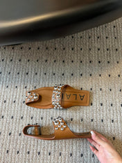 ALAIA FOLDED FLAT MULES WITH SPHERES ON COPPER BROWN CALFSKIN