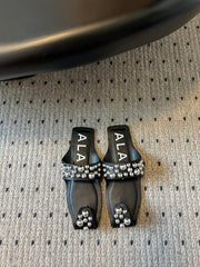 ALAIA FOLDED FLAT MULES WITH SPHERES ON BLACK CALFSKIN