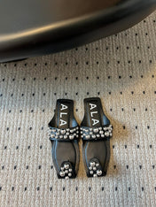 ALAIA FOLDED FLAT MULES WITH SPHERES ON BLACK CALFSKIN