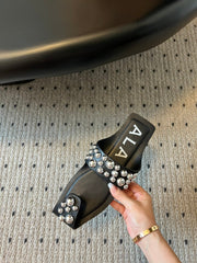 ALAIA FOLDED FLAT MULES WITH SPHERES ON BLACK CALFSKIN