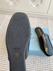 MULES IN BLACK GLOSSY SHEEPSKIN GOLD LETTERING LOGO