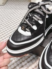 CHANEL 25S THICK-SOLE SNEAKERS IN BLACK AND WHITE CALFSKIN WITH FUR LINING