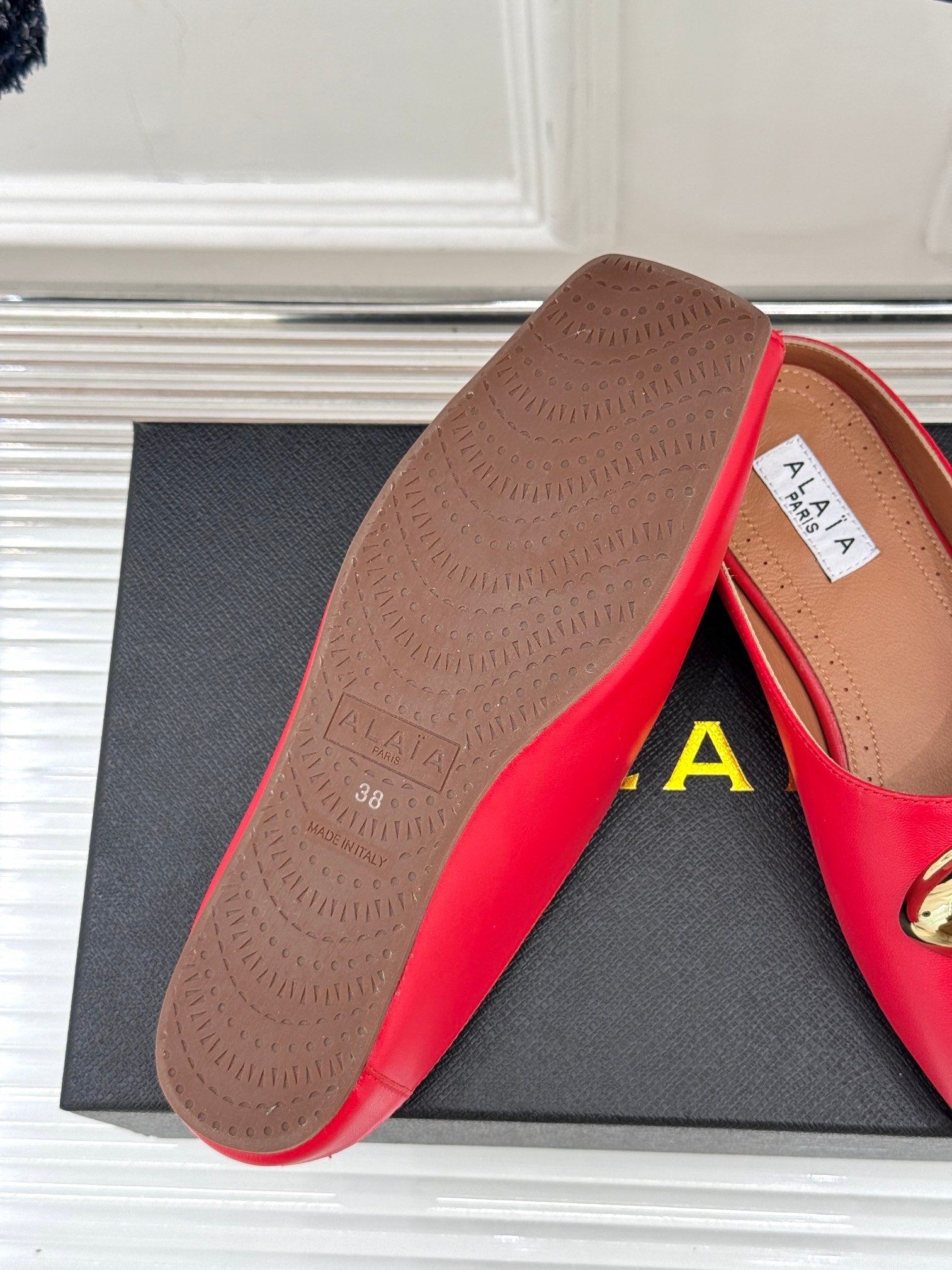 ALAIA FLAT MULE IN CRIMSON RED LAMBSKIN WITH GOLD HARDWARE