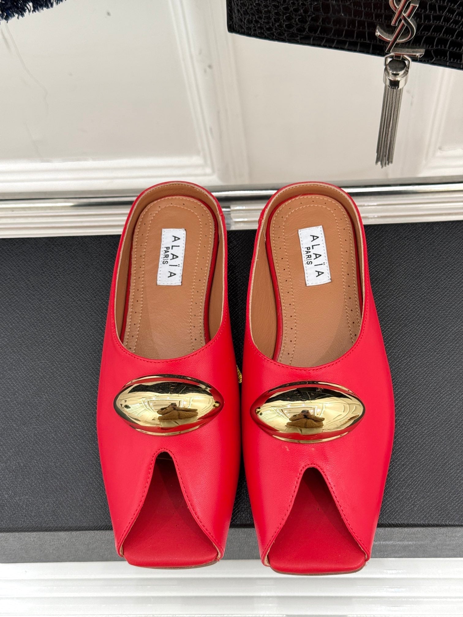 ALAIA FLAT MULE IN CRIMSON RED LAMBSKIN WITH GOLD HARDWARE