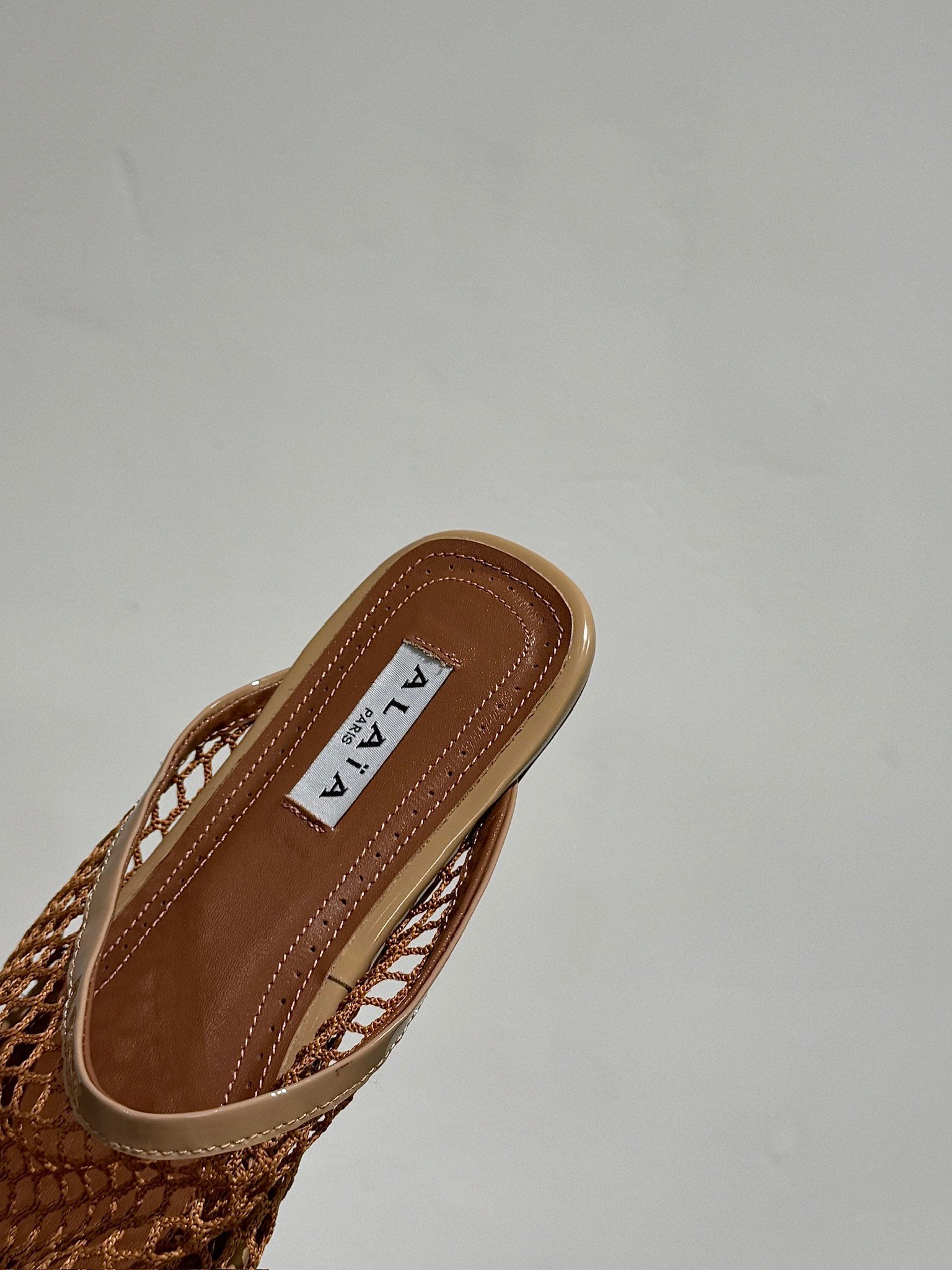 ALAIA FLAT MULES IN COPPER BROWN MESH FISHNET