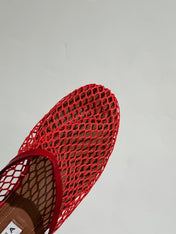 ALAIA FLAT MULES IN CHERRY RED MESH FISHNET