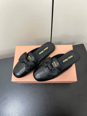 BOW MULES IN BLACK SHEEPSKIN