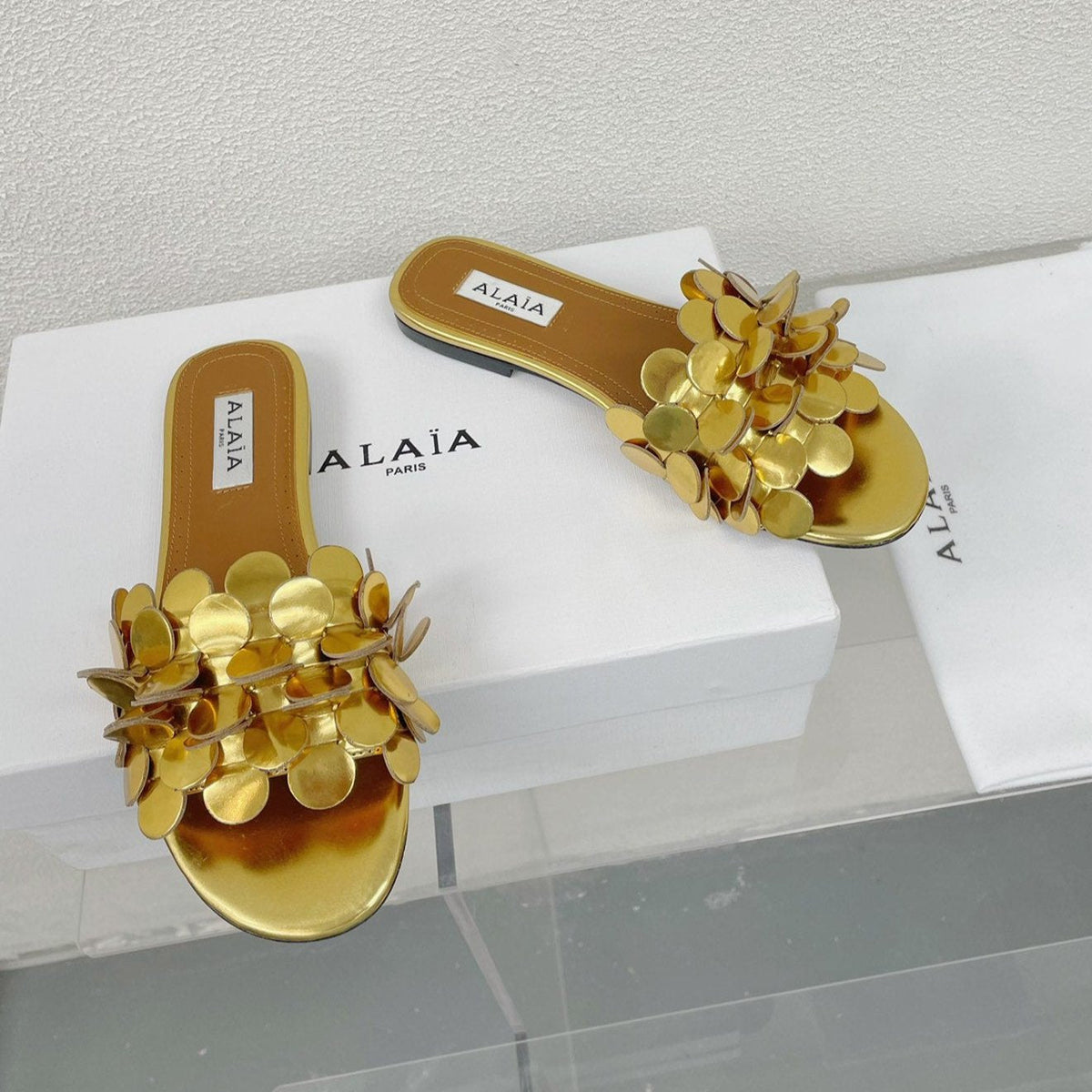 ALAIA FLAT MULE IN GOLDEN GLOSSY LAMBSKIN