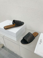 ALAIA VIENNE FLAT MULES IN BLACK LAMBSKIN