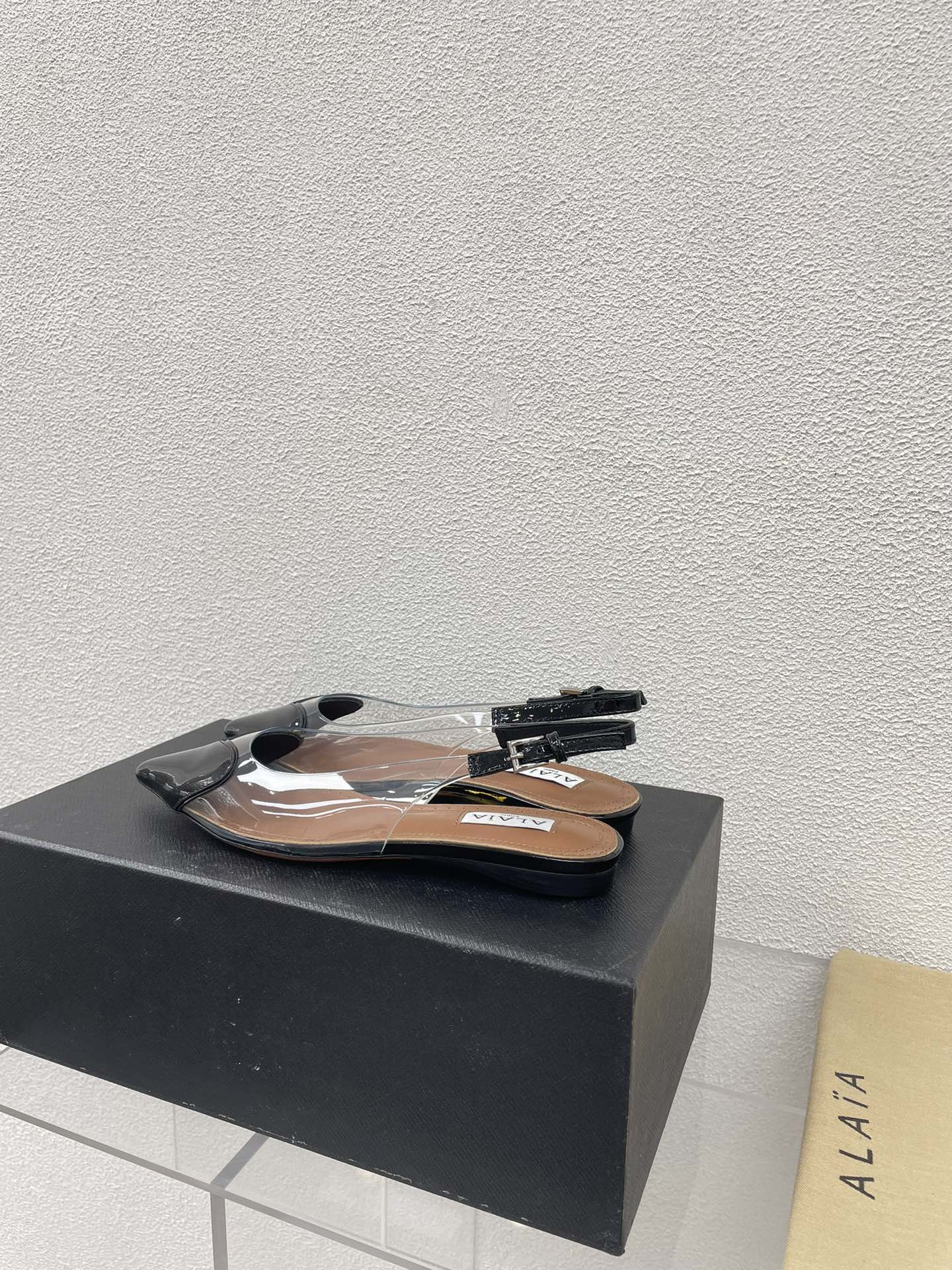 ALAIA LE COEUR FLAT SLINGBACKS IN BLACK PATENT LAMBSKIN
