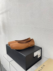 ALAIA BALLET FLATS IN COPPER BROWN CALFSKIN