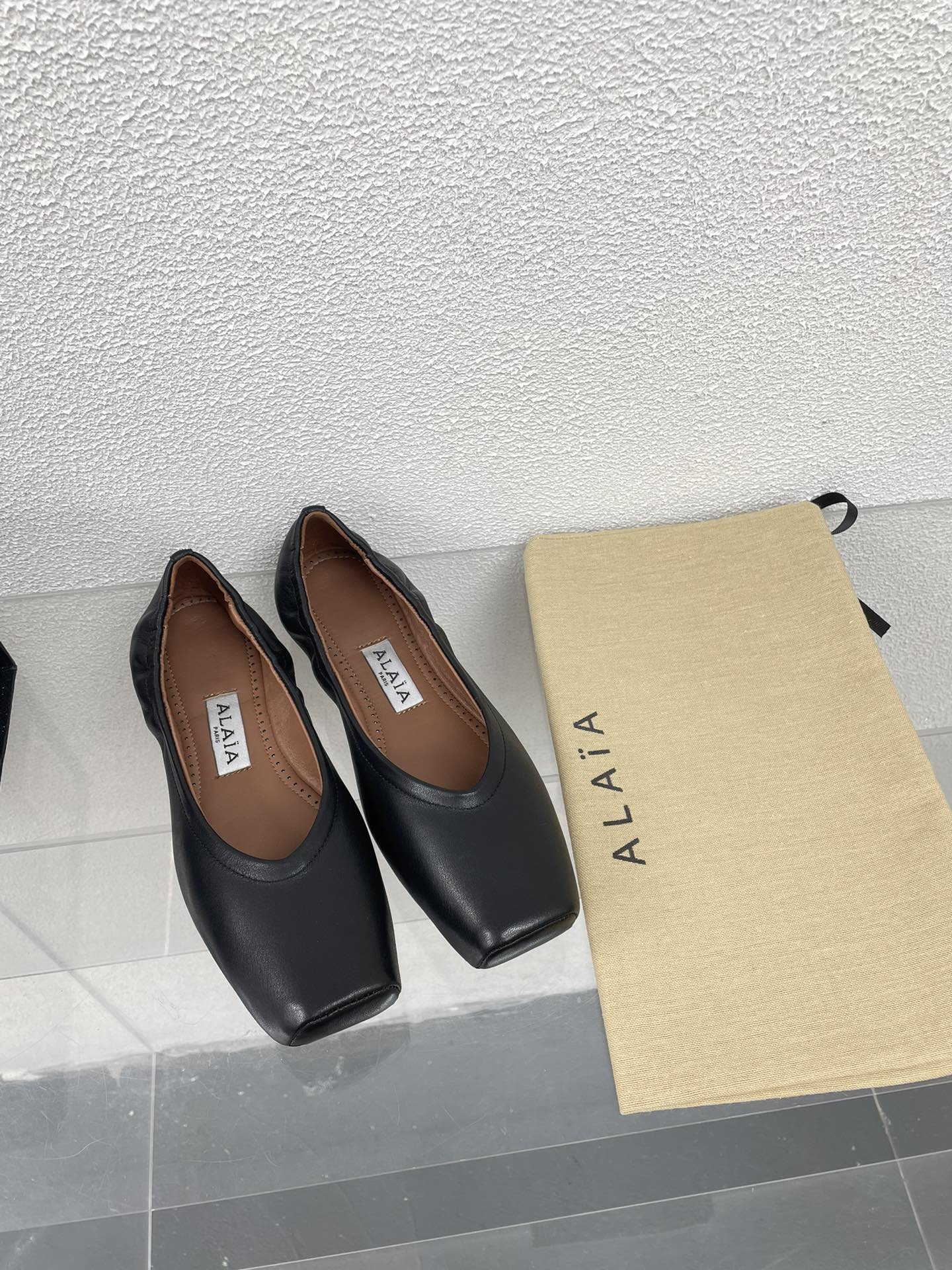ALAIA BALLET FLATS IN BLACK CALFSKIN