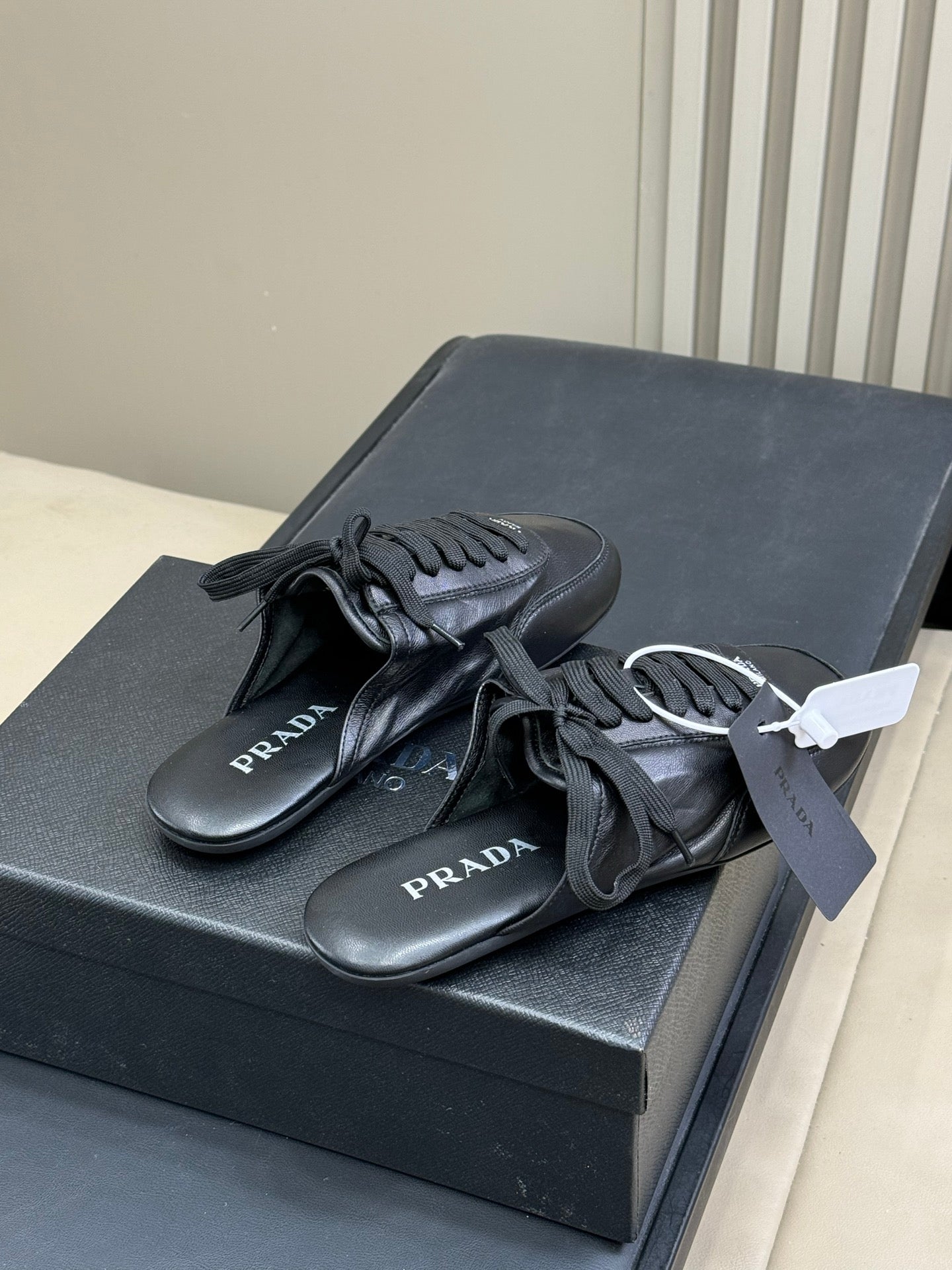 PRADA 25S COLLAPSE MULES IN BLACK CALFSKIN